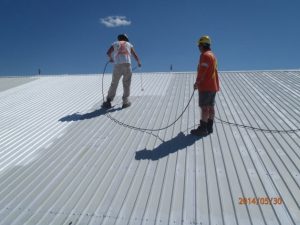 Installing roof coating with high powered sprayer or a roller - Roof Armour